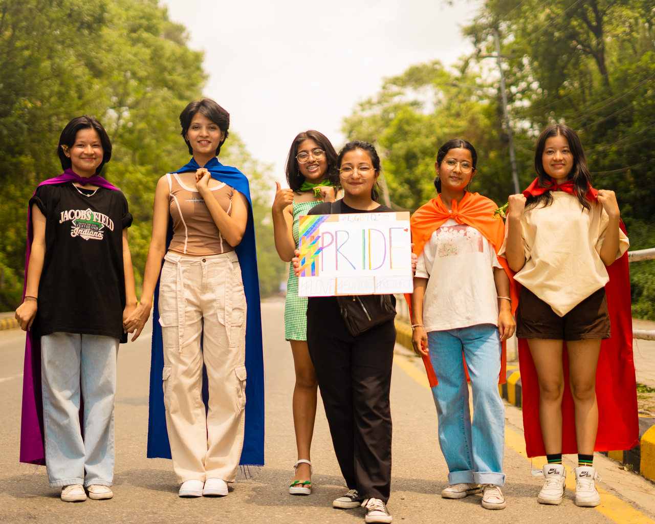 Mastering the First Impression: Your intriguing post title goes here A group of diverse young adults in colorful capes celebrating pride outdoors with a handmade sign.