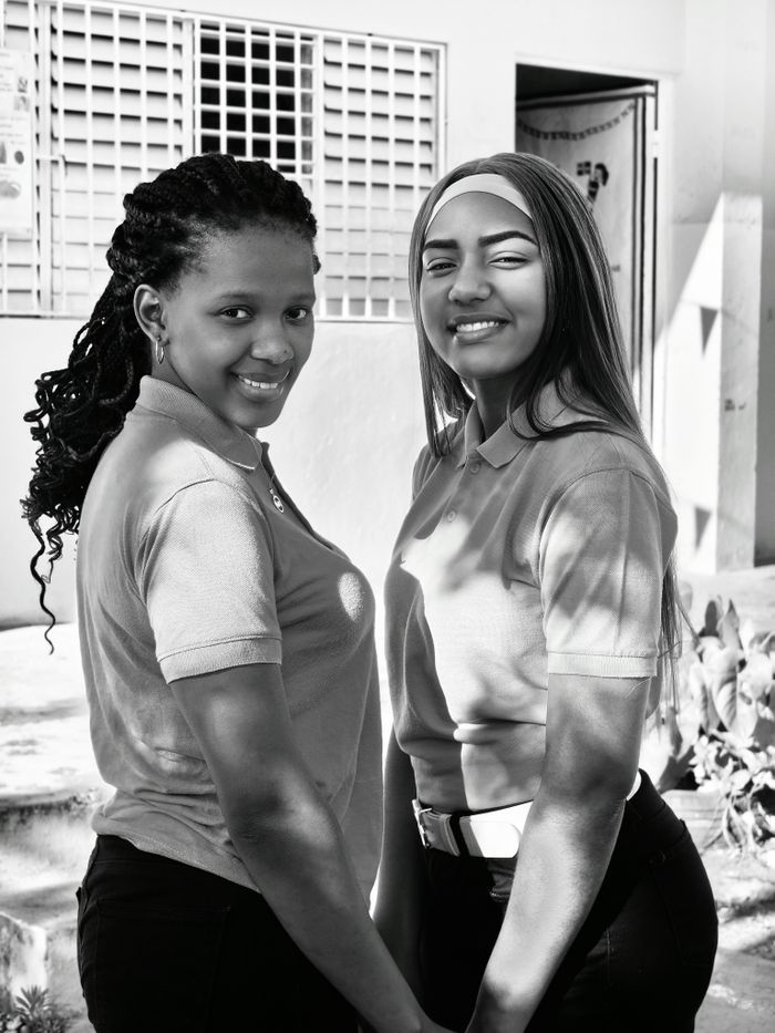Black and white portrait of two smiling women outdoors. Great for diversity and friendship themes.